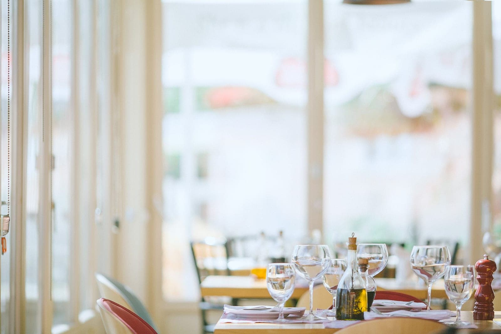 Gedekte tafel met glazen in een licht restaurant